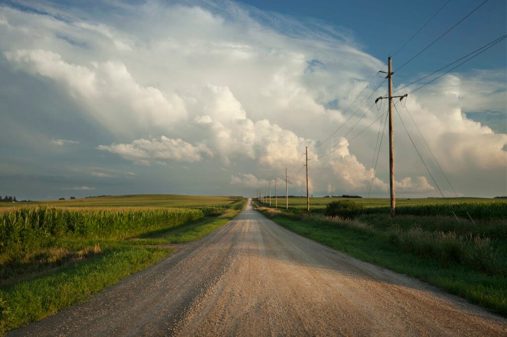 Rural Road Beneath Dramatic Clouds at Sundown